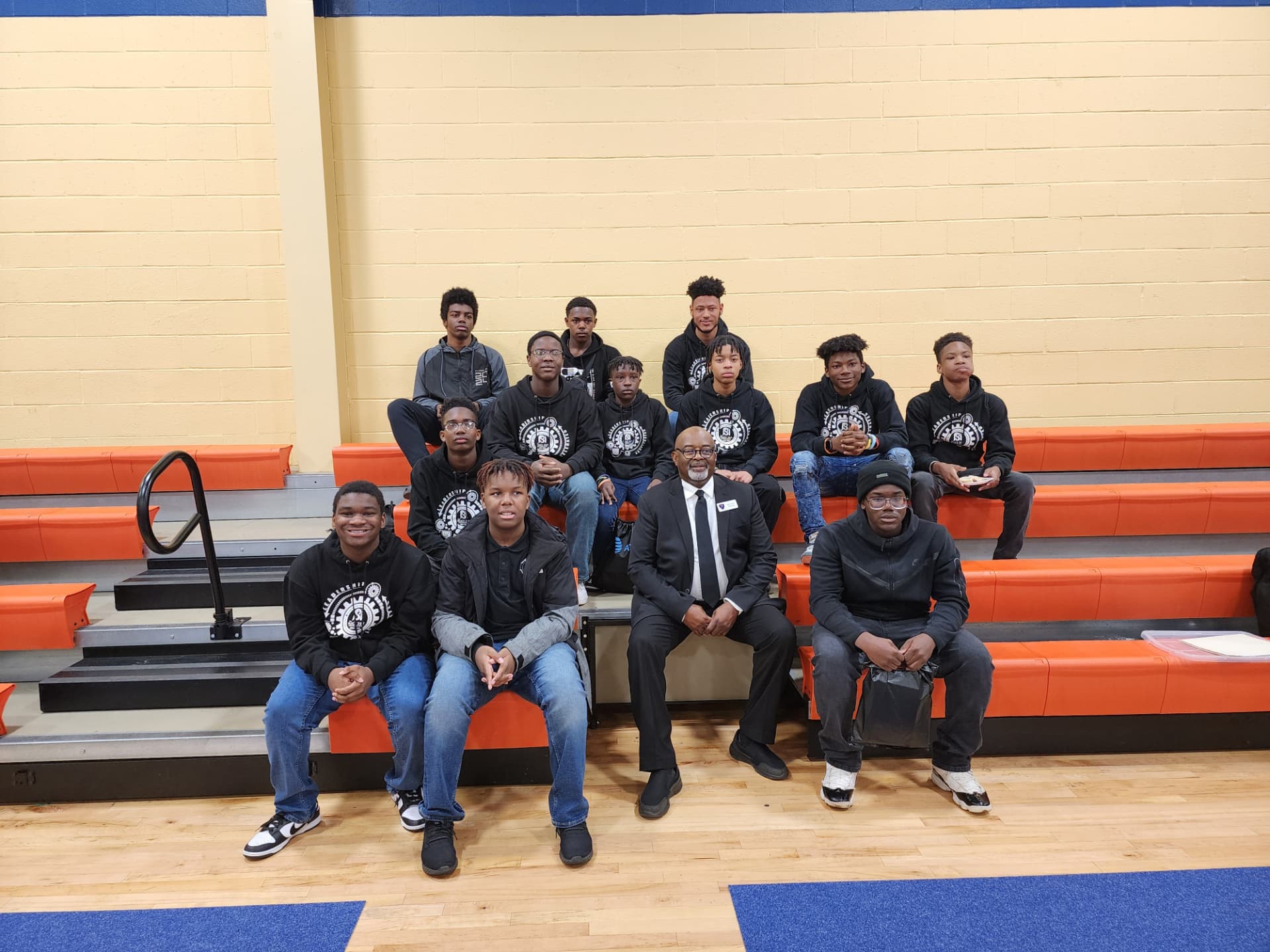 Young men from a school leadership program seated in a gym